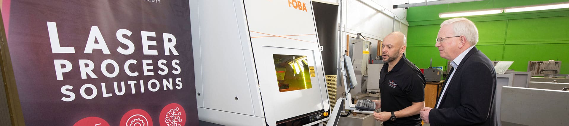 Engineer showing a business executive the basics of a FOBA M3000 laser marking system